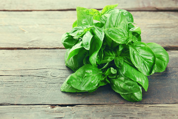 Fototapeta premium Green fresh basil on wooden background