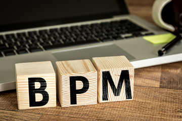 BPM (Business Process Management) written on a wooden cube in a office desk 