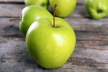 Ripe green apples on wooden table close up
