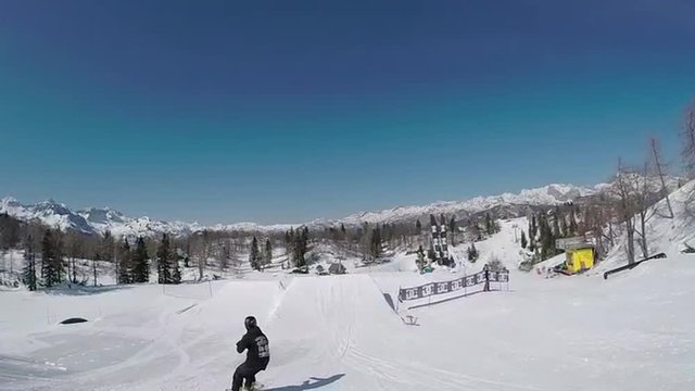SLOW MOTION: Young snowboarder jumping the kicker in snow park