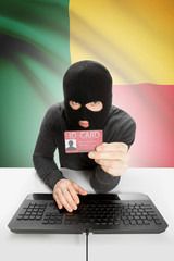 Hacker with flag on background holding ID card in hand - Benin
