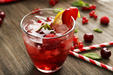 Glass of berry juice on wooden table, closeup
