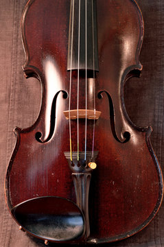 Antique violin against gray background