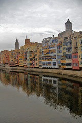 Fototapeta premium Reflections from houses in Onyar River, in Girona, one cloud day