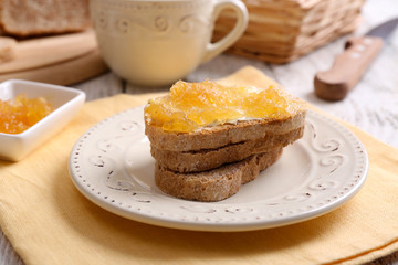 Fresh toast with butter and jam on table close up