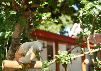 Bird statue hang under tree branch