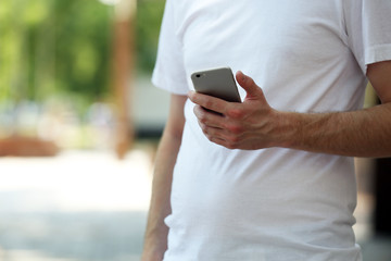 Man holding smart mobile phone outdoors