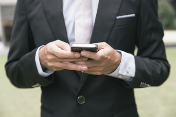 handsome business man writting email or message on phone