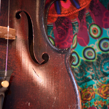 Antique violin closeup against colorful print