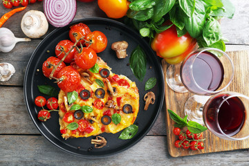 Decorated pizza with vegetables on pan on wooden background