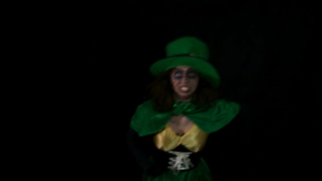 funny leprechaun is waving to the viewer, black background, hd video