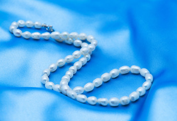 Pearls a necklace on a silk fabric