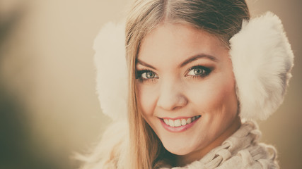 Portrait of pretty smiling woman in fur earmuffs.