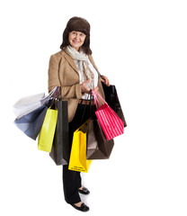 Mature good looking woman with lots of shopping bags, happily smiling after shopping. 