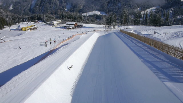 AERIAL: Snowboarder jumping in half pipe