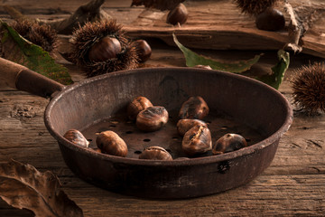 Roasted chestnuts in a rusty pan, autumnal themed Italian traditional cuisine