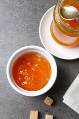 Tasty jam in the jar and bowl, crackers and fresh buns close-up