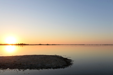 Fototapeta premium Golden sunrise over calm water