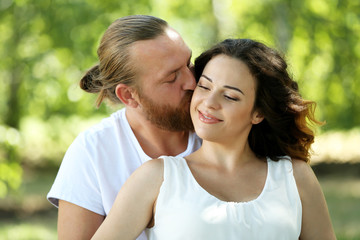 Fototapeta premium Portrait of embracing couple in the park, close up
