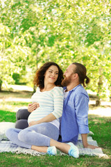 Happy moments in waiting baby's birth - man and woman together in the park