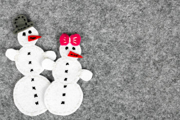 Christmas background with felt decoration: couple of snowman