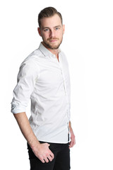 Fototapeta premium A man in his 20s wearing a white shirt and black jeans, standing with his hands in pocket in a studio. White background.
