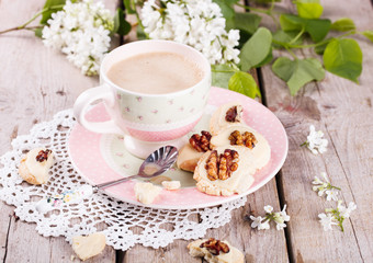 Shortbread cookies with white chocolate and walnuts and a Cup of coffee with milk.
