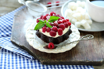 Sweet cakes with raspberries on wooden table background