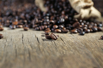 Aromatic coffee beans scattered on wooden background