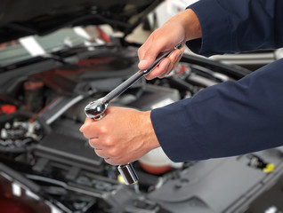 Hand of car mechanic in auto repair service. 