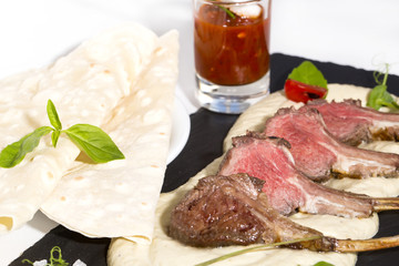 lamb ribs cooked on the grill served on a hot stone