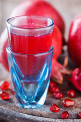 Juicy pomegranates,whole and broken and pomegranate juice on wooden background.selective focus.