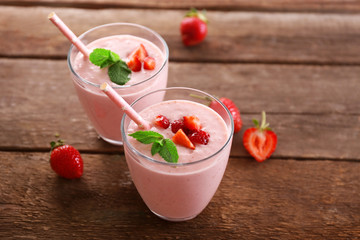 Fresh strawberry yogurt with berries around on wooden background