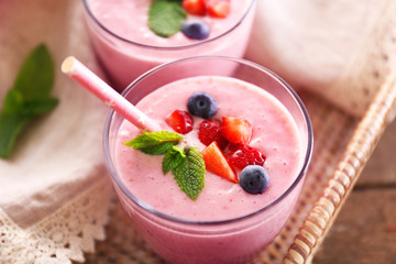 Fresh strawberry yogurt on wicker tray on wooden background
