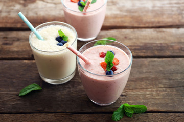 Fresh strawberry and milk yogurts with berries on wooden background