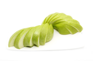 ripe apple is sliced on a plate one on a white background