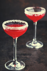 Red alcoholic cocktail  in a glass on a black background.Vintage style.Copy space. selective focus.