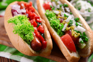 Hot dogs and vegetables on wooden cutting board