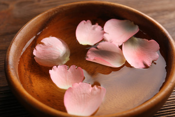 Pink rose petals in a bowl of water, close-up
