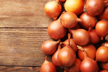 Fresh onions on wooden background