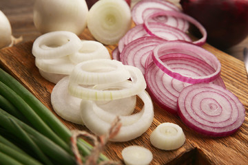 Composition of onions and garlic on wooden background, close up
