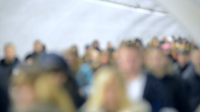 Crowd of people walking in the subway at rush hour, defocused