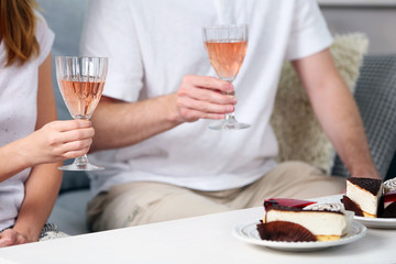 Friends hands with glasses of wine and desserts, close up