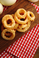 Chips rings with sauce and onion on cutting board closeup