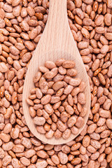 Brown pinto beans in wooden spoon and brown pinto beans  backgro