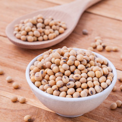 Close Up soy beans in wooden bowl and spoon on wooden background