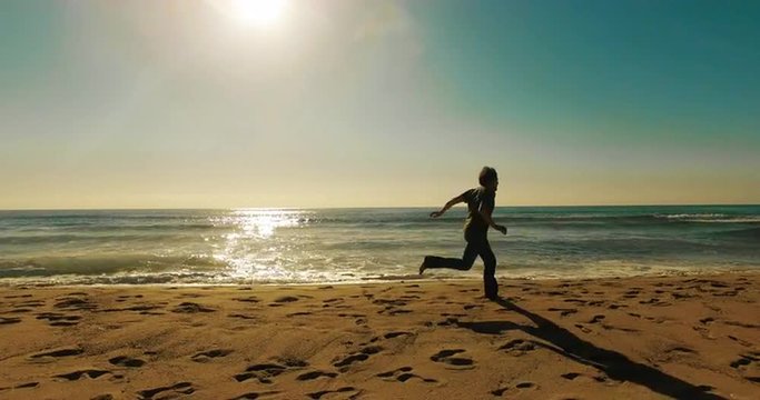 Man running on beach scared aerial shot