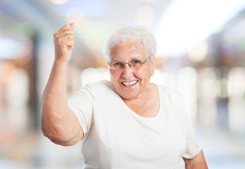 portrait of old woman doing a winner gesture