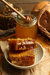 Honeycombs on plate, hot buns on wooden background