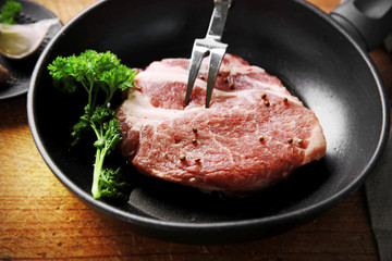 Marbled beef steak on pan and spices on wooden background